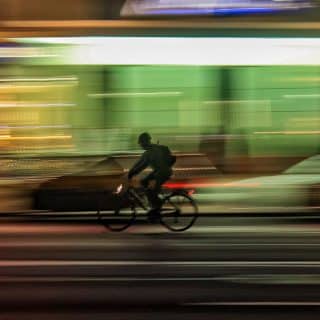 Image décorative - Personne faisant du vélo en ville de nuit