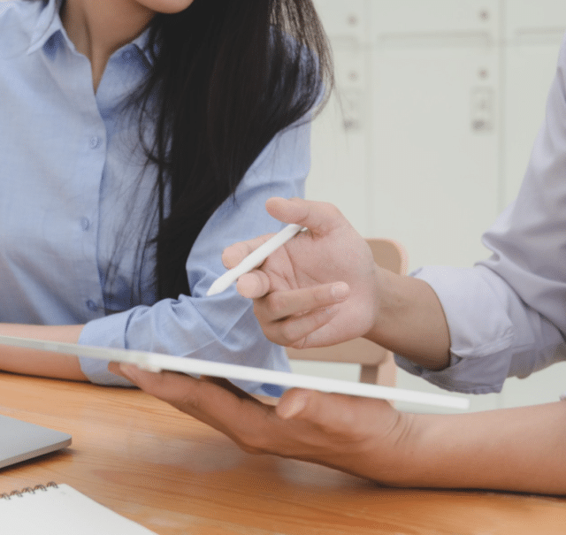 deux personnes en chemise bleue discutent avec une tablette