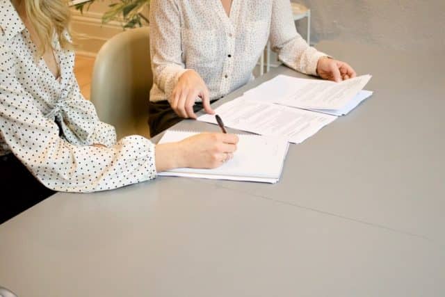 deux personnes travaillent sur des documents